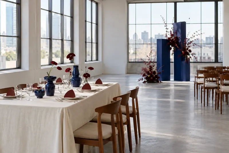 Original artful wedding concept in a gallery-like room with cobalt accents, red flowers and simple geometric decorative details.